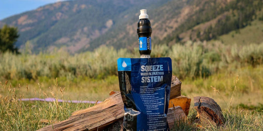 Sawyer Squeeze water filter attached to pouch in a mountain setting
