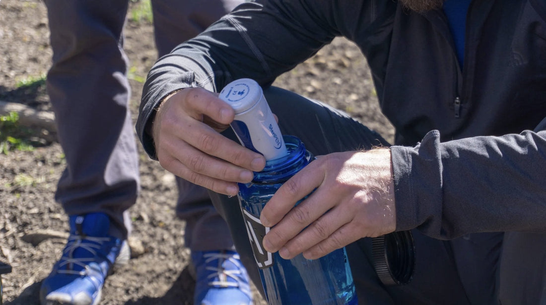 Backpacker using a Steripen on a hike in the wilderness